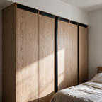 Matte black recessed aluminium handles fitted to oak wardrobe doors
