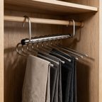 Chrome multi-tier trouser hanger on a wardrobe rail holding folded trousers